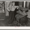 J. A. Fisher, storekeeper, postmaster and depot agent of Funkley, Minnesota, by stove of his own creation