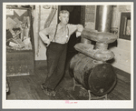 J. A. Fisher, storekeeper, postmaster and depot agent of Funkley, Minnesota, by stove of his own creation.  Funkley is rapidly becoming a "ghost town."