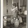 Lumberjack washing clothes at logging camp near Effie, Minnesota