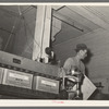 Removing finished cartons of packaged rice from conveyer-presser. State rice mill, Abbeville, Louisiana