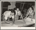 Cutting pieces of crepe paper to be used in decorating float. National Rice Festival, Crowley, Louisiana