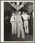 Fais-do-do dance. Cajun men congregate in center of hall. Near Crowley, Louisiana