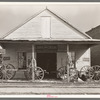 Wagons on porch of farm implements dealer. Erath, Louisiana