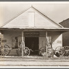 Wagons on porch of farm implements dealer. Erath, Louisiana