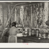 Mrs. M. LaBlanc straightening articles in corner of kitchen in present home. Note the waterstained walls caused by leaking roof. Morganza, Louisiana