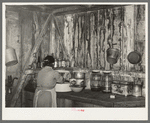 Mrs. M. LaBlanc straightening articles in corner of kitchen in present home. Note the waterstained walls caused by leaking roof. Morganza, Louisiana