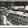 Worker winding cotton thread onto large spools. Laurel cotton mills, Laurel, Mississippi