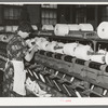 Worker winding cotton thread onto large spools. Laurel cotton mills, Laurel, Mississippi