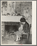 Wife and daughter of FSA client in front of fireplace of temporary home. Transylvania, Louisiana