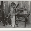 Negro child playing phonograph in cabin home. Transylvania Project, Louisiana