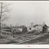 Farmstead of Negro sharecropper with sharecropper carrying water. Near Transylvania, Louisiana