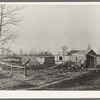 Farmstead of Negro sharecropper with sharecropper carrying water. Near Transylvania, Louisiana