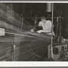 Operator repairing break in thread in warp winding. Laurel cotton mills, Laurel, Mississippi