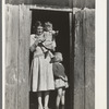 Mrs. Ed Bagget with two children in doorway of sharecropper cabin near Laurel, Mississippi
