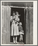 Mrs. Ed Bagget with two children in doorway of sharecropper cabin near Laurel, Mississippi