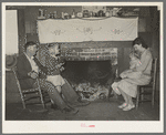Bagget family in front of fireplace which is means of heating in the winter. Laurel, Mississippi