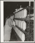 Removing spindles of large cotton thread from thread-making machinery. Laurel Cotton Mill, Laurel, Mississippi