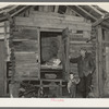 Mot Tucker in front of corncrib home showing sleeping quarters. Antioch, Mississippi