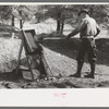 Prospector throwing a shovel of gold bearing dirt into the papago, Pinos Altos, New Mexico