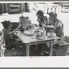 The Caudill family eating dinner in the open the day they were moving their dugout, Pie Town, New Mexico