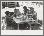 The Caudill family eating dinner in the open the day they were moving their dugout, Pie Town, New Mexico