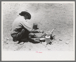 Faro Caudill frying eggs over camp fire the day he was moving his dugout, Pie Town, New Mexico