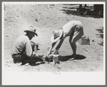Faro and Doris Caudill cooking dinner over camp fire, Pie Town, New Mexico