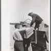 Mr. Keele taking crate of grapefruit from truck, General store, Pie Town, New Mexico