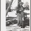 Woman guiding the drilling tool for water well drilling, Pie Town, New Mexico