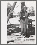 Woman guiding the drilling tool for water well drilling, Pie Town, New Mexico