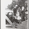 Pouring water on rope and pulley to cool them off while drilling water well with cable tools, Pie Town, New Mexico