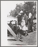 Pouring water on rope and pulley to cool them off while drilling water well with cable tools, Pie Town, New Mexico