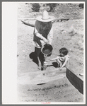 Mrs. Caudill and daughter watering frame garden, Pie Town, New Mexico