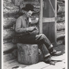 Farmer rolling a cigarette. Construction of log house is shown. This farmer rents farm and house from the man who homesteaded the place but is now unable to farm, Pie Town, New Mexico