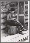 Farmer rolling a cigarette. Construction of log house is shown. This farmer rents farm and house from the man who homesteaded the place but is now unable to farm, Pie Town, New Mexico