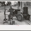 Homesteader pumping water which he will haul home from town. Wells require cash to drill and some farmers have not yet been able to drill their own wells, Pie Town, New Mexico