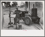 Homesteader pumping water which he will haul home from town. Wells require cash to drill and some farmers have not yet been able to drill their own wells, Pie Town, New Mexico