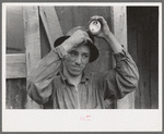 Young mine worker taking lamp from his hat at the end of the day's work, Mogollon, New Mexico