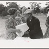 Mrs. Stagg handing pan of food to Mr. Stagg to put on the table at dinner of all day community sing, Pie Town, New Mexico