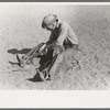 Cowboy testing stirrups at rodeo before broncbusting, Quemado, New Mexico