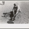 Cowboy testing stirrups at rodeo before broncbusting, Quemado, New Mexico