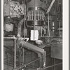 Cans are fed by gravity to a sterilizer and they are then filled in a rotary machine at the grapefruit juice canning plant. Weslaco, Texas