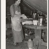 White migrant mother making biscuits in tent home