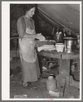 White migrant mother making biscuits in tent home