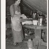 White migrant mother making biscuits in tent home