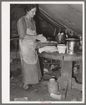 White migrant mother making biscuits in tent home