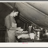White migrant mother making biscuits in tent home