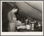 White migrant mother making biscuits in tent home