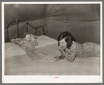 Child migrant with doll in tent home. Harlingen, Texas