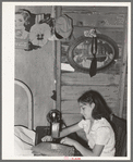 Mexican girl sewing in their home. Robstown, Texas. Contrary to the prevalent idea, Mexicans generally are extremely neat and clean even when they live in most crowded conditions